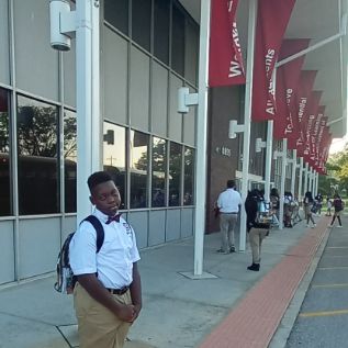  student standing in front of building before walking in 